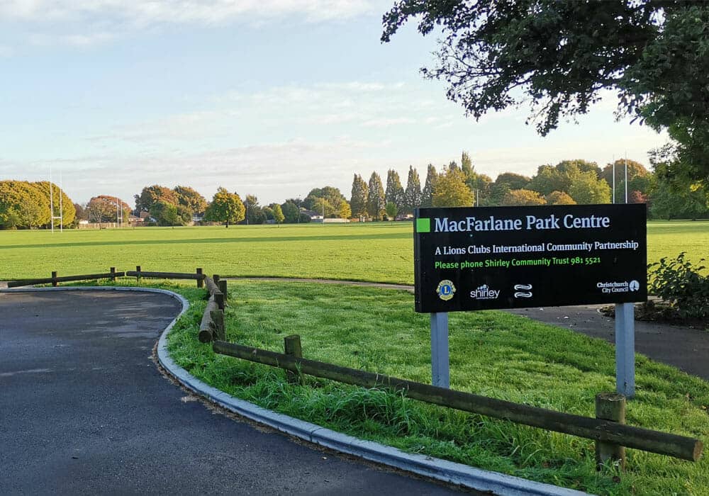 MacFarlane Park Centre sign at edge of large grassy playing field